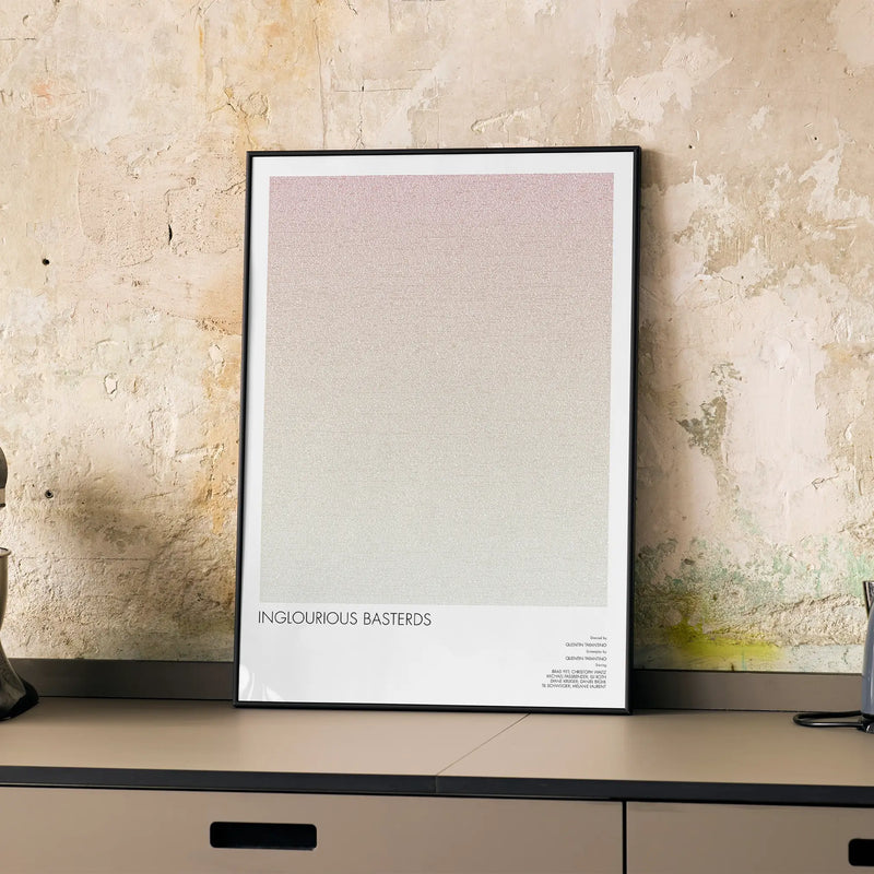 A framed Inglourious Basterds movie script poster displayed on a cabinet in a minimalist interior.
