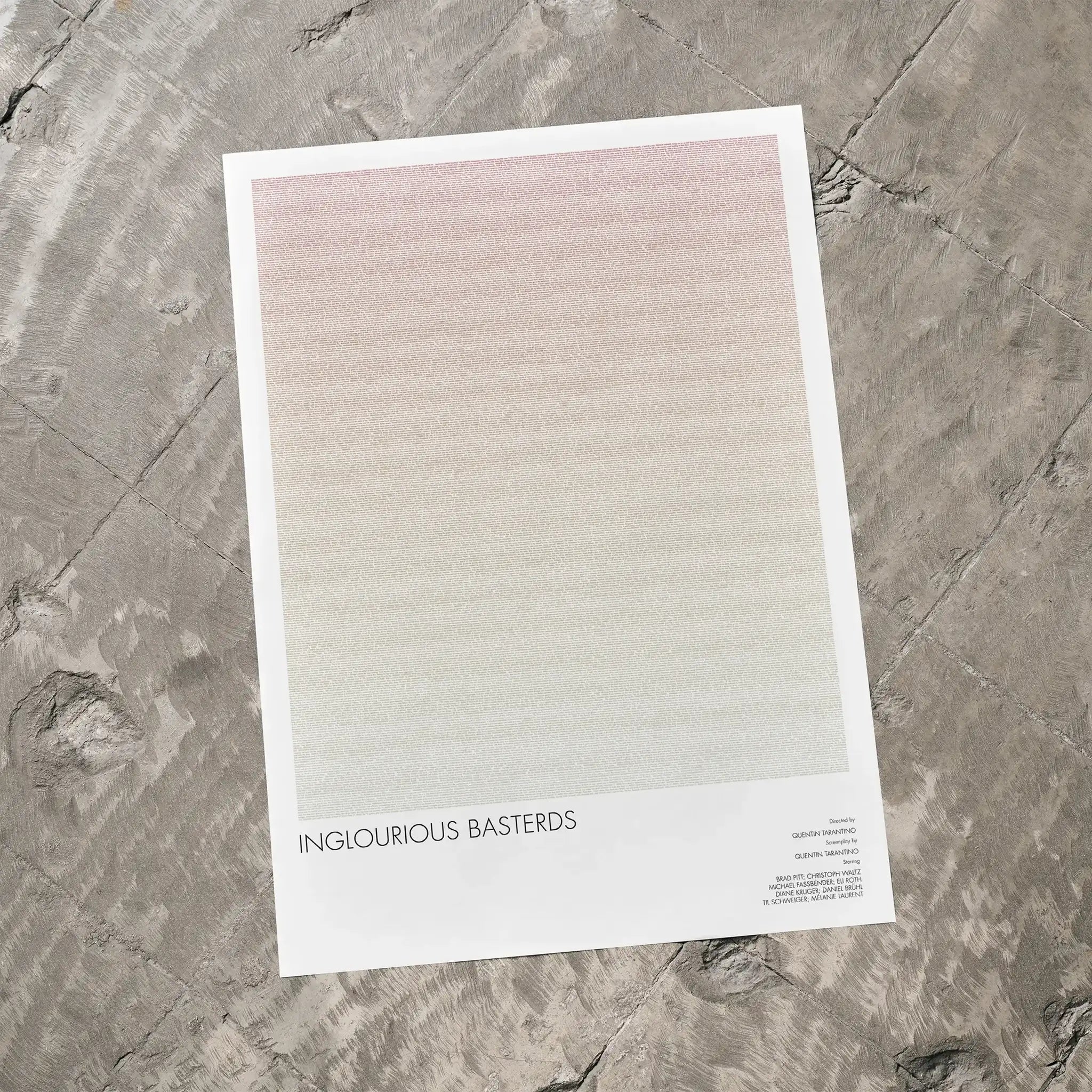 A Inglourious Basterds movie script poster laid flat on a textured floor surface.