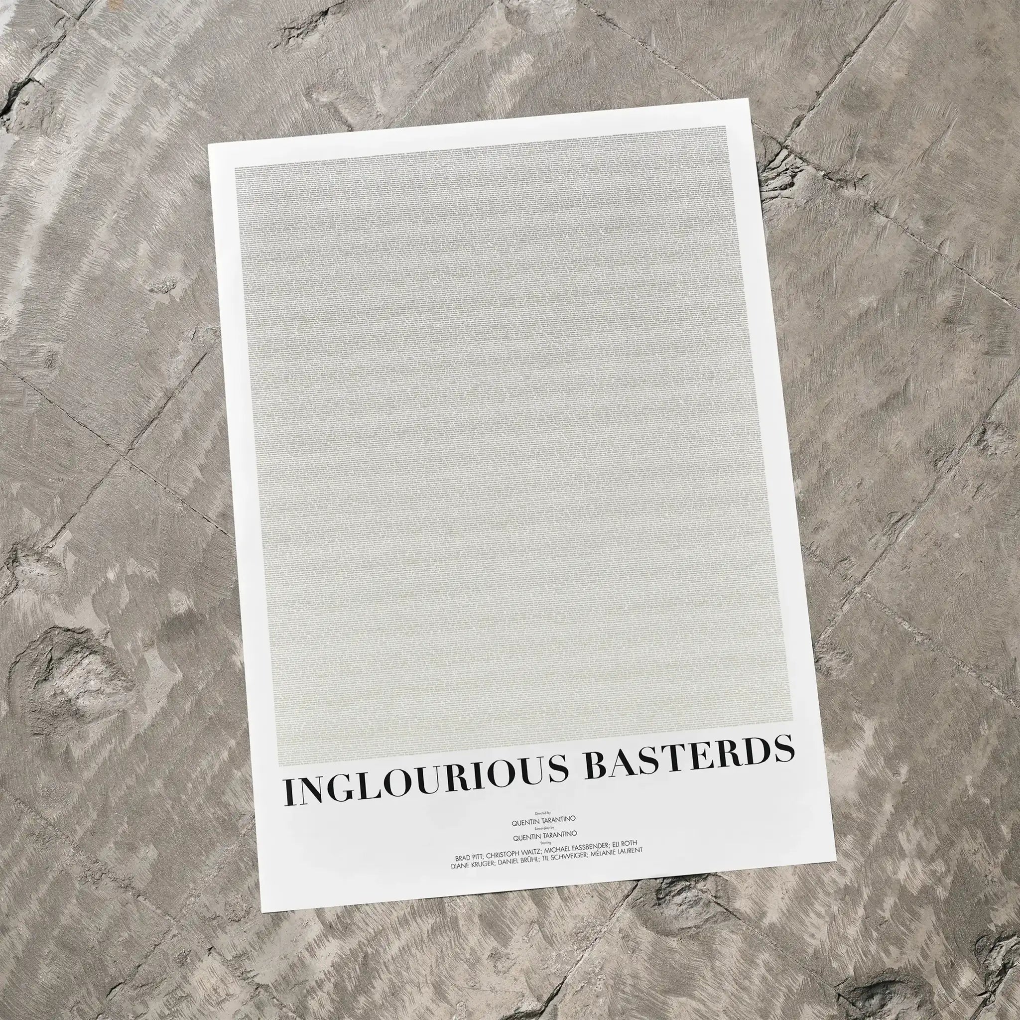 A Inglourious Basterds movie script poster laid flat on a textured floor surface.