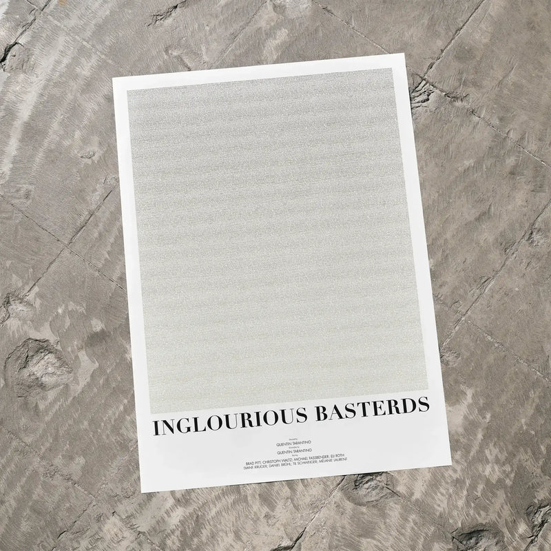 A Inglourious Basterds movie script poster laid flat on a textured floor surface.