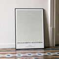 A framed Inglourious Basterds movie script poster leaning against a wall in a minimalist interior.