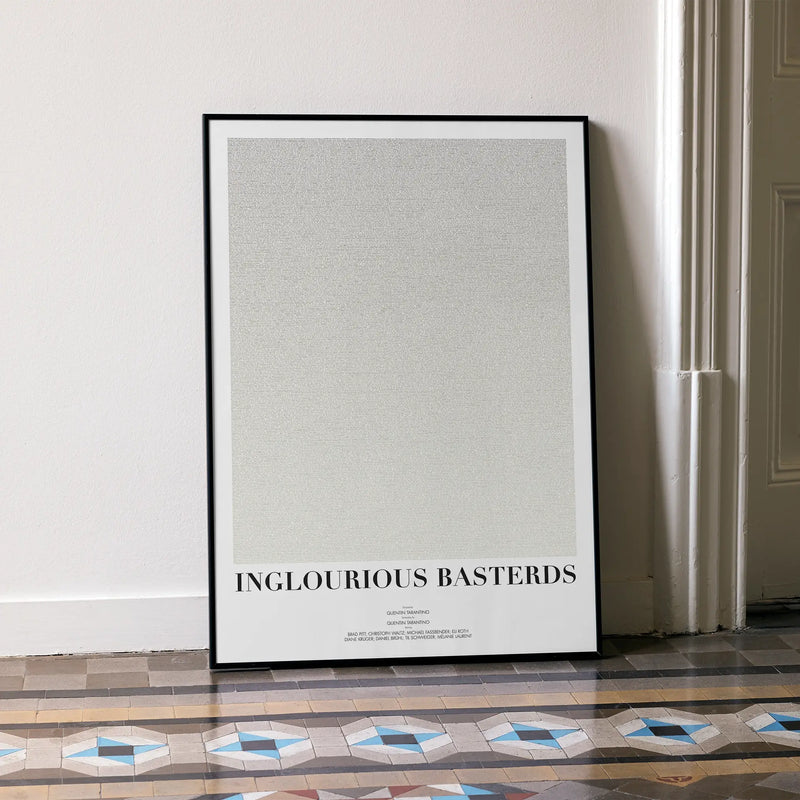 A framed Inglourious Basterds movie script poster leaning against a wall in a minimalist interior.