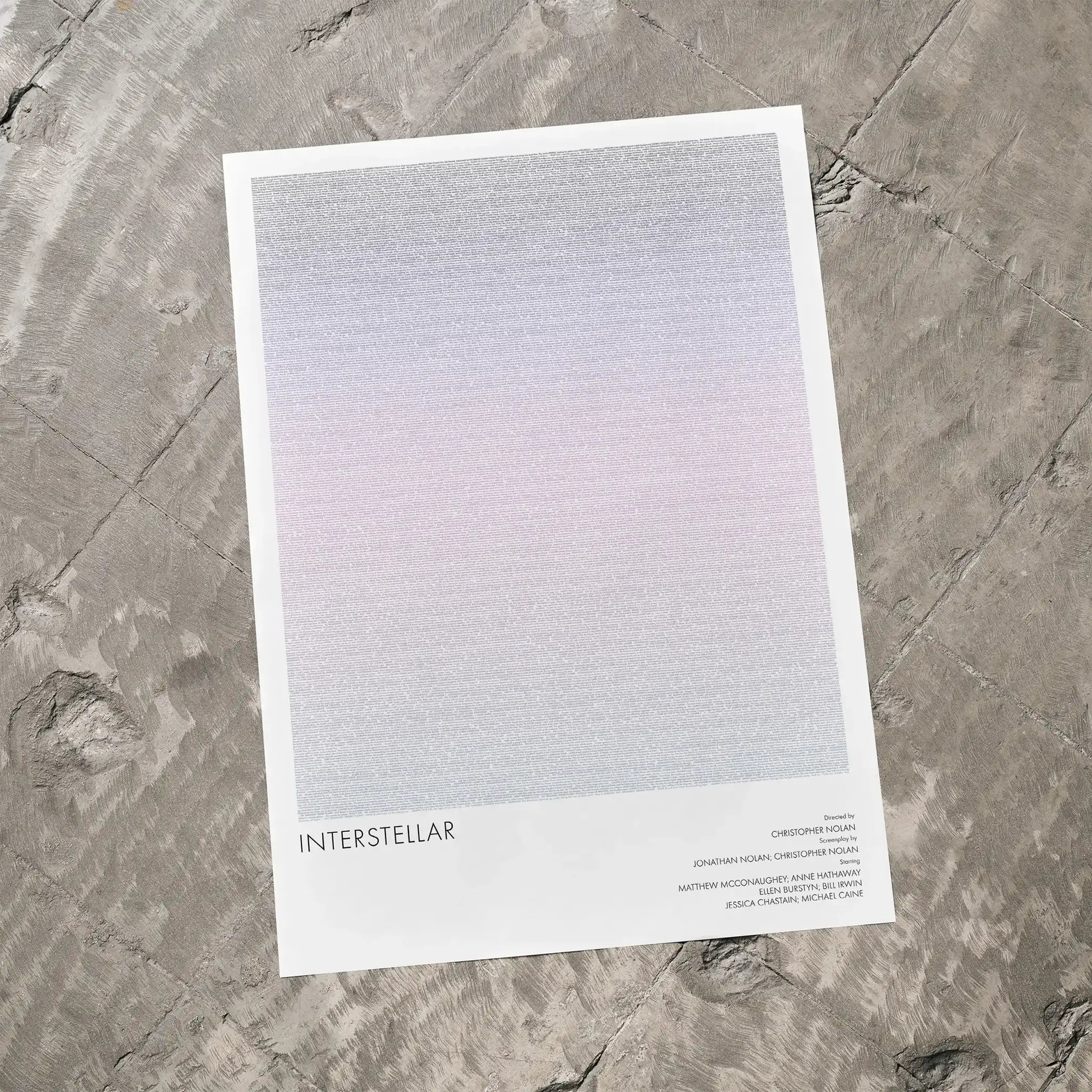 A Interstellar movie script poster laid flat on a textured floor surface.