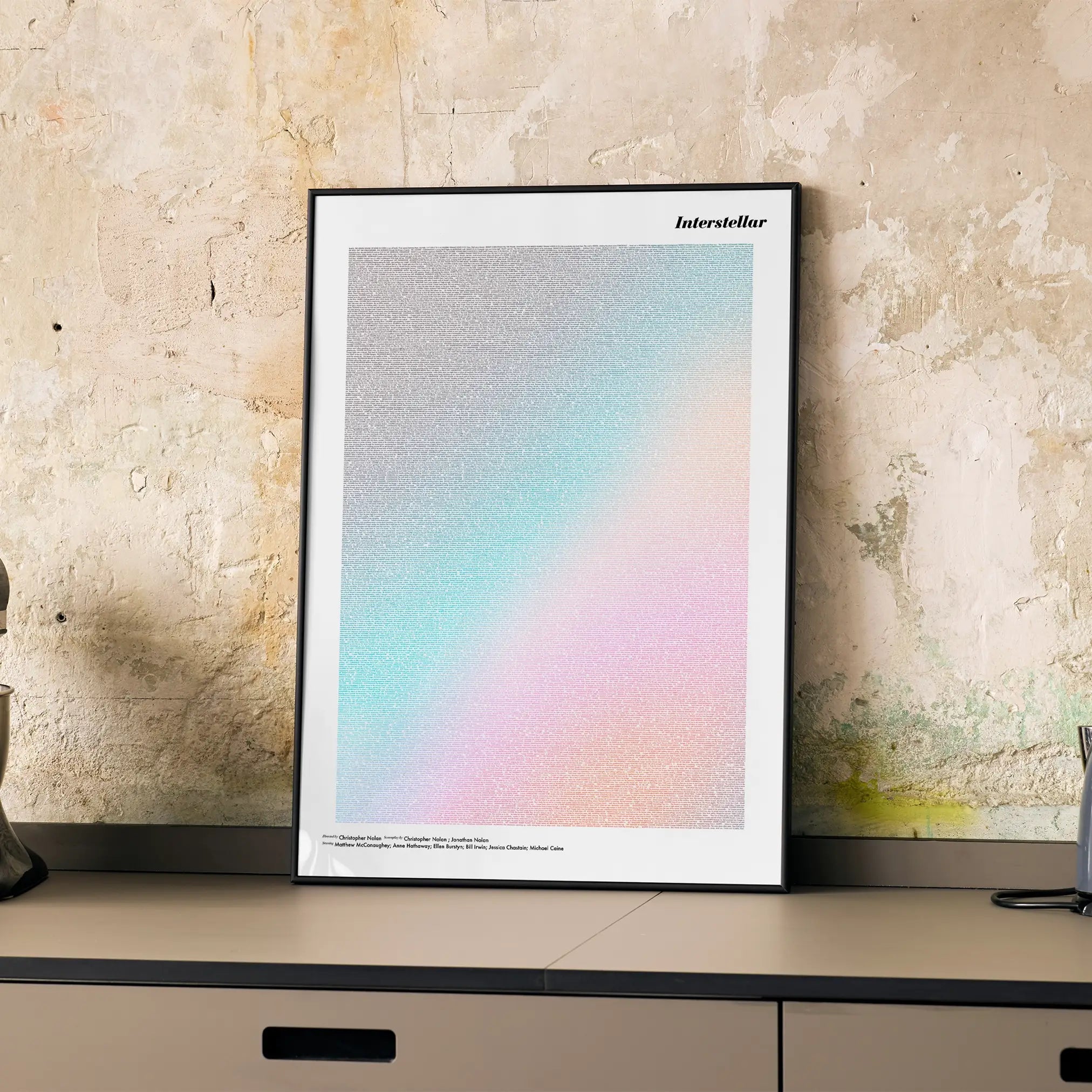 A framed Interstellar movie script poster displayed on a cabinet in a minimalist interior.