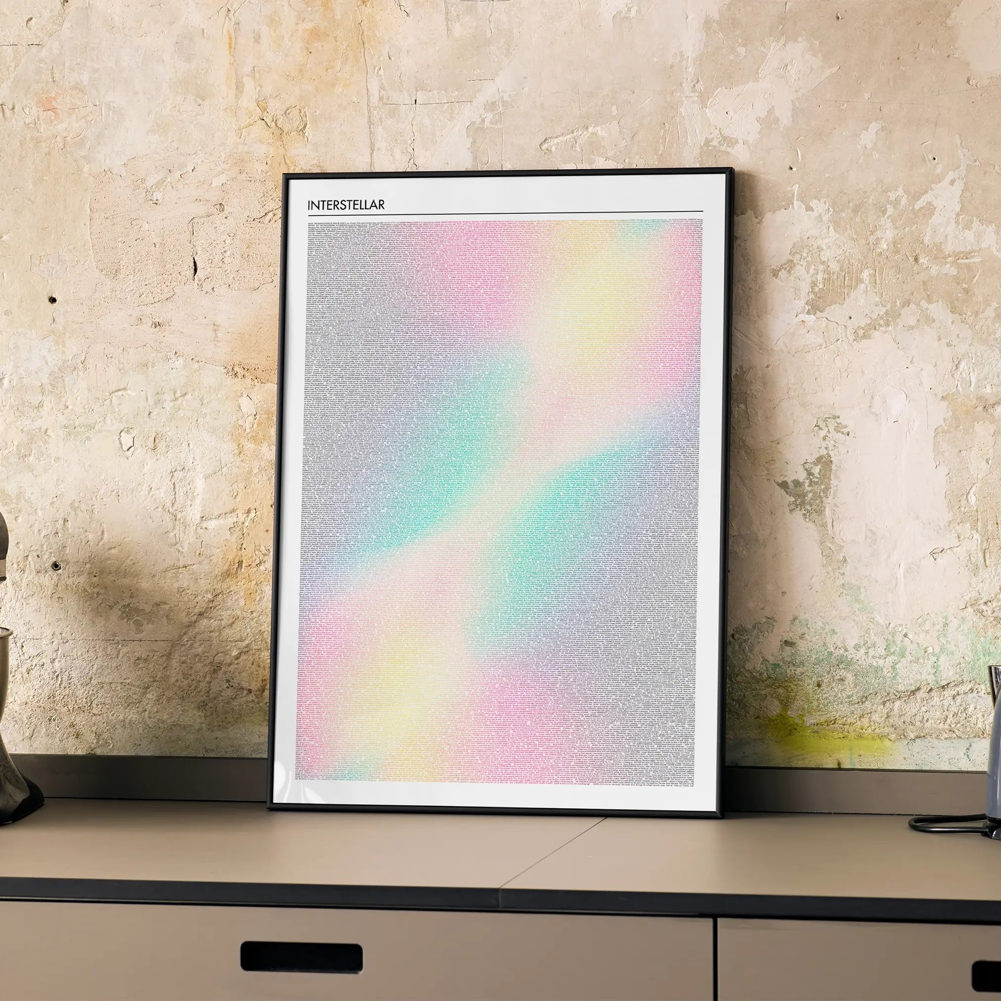 Framed Interstellar movie poster artwork with a rainbow gradient on a textured wall.