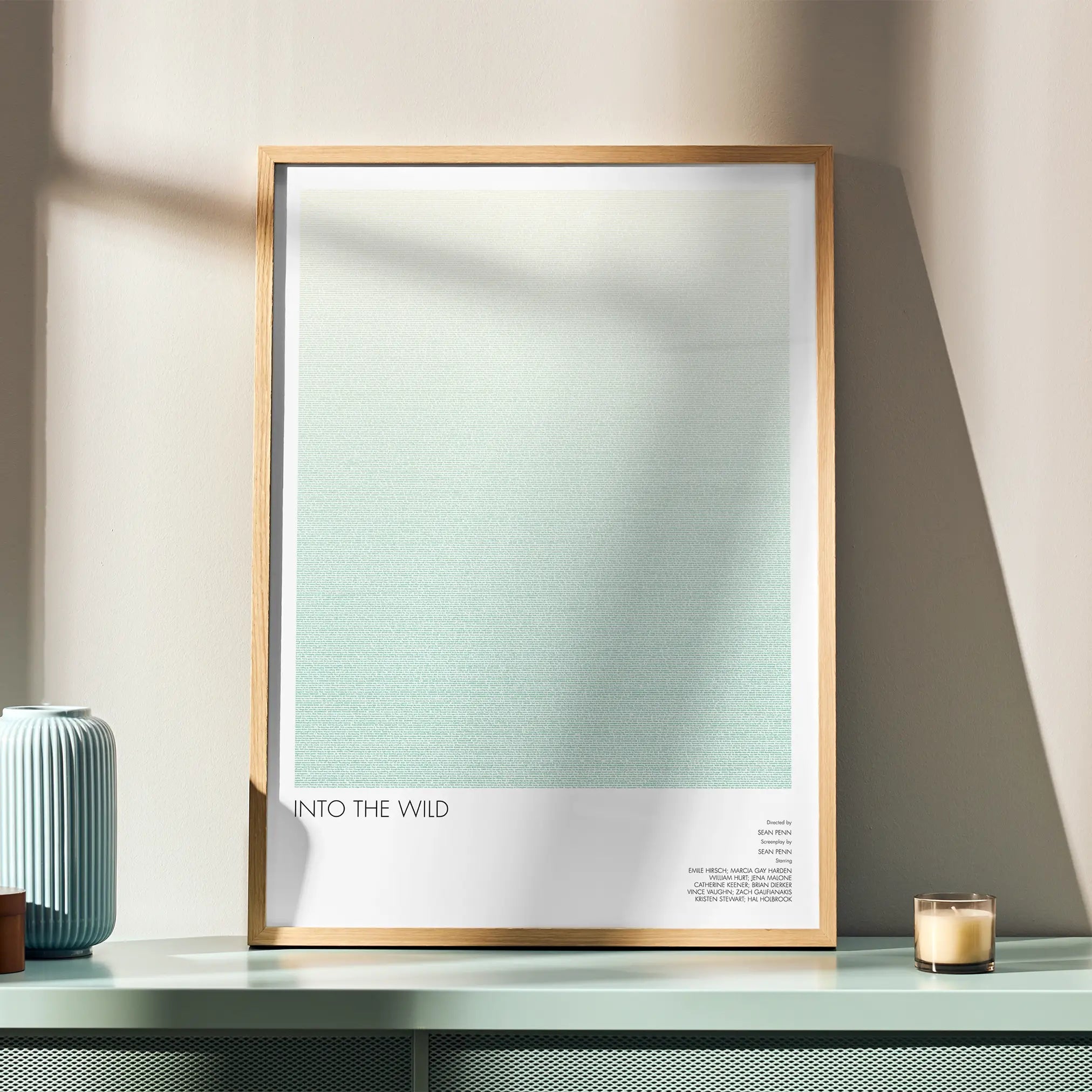 A framed Into the Wild movie script poster displayed in a simple modern interior.