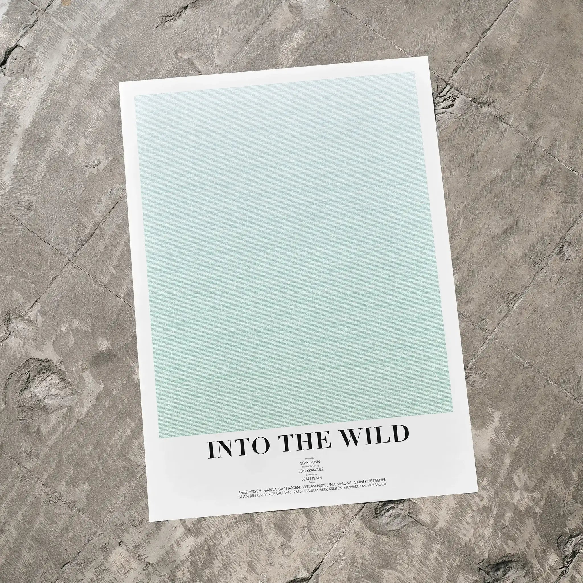 A Into the Wild movie script poster laid flat on a textured floor surface.