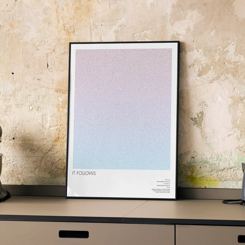 A framed It Follows movie script poster displayed on a cabinet in a minimalist interior.