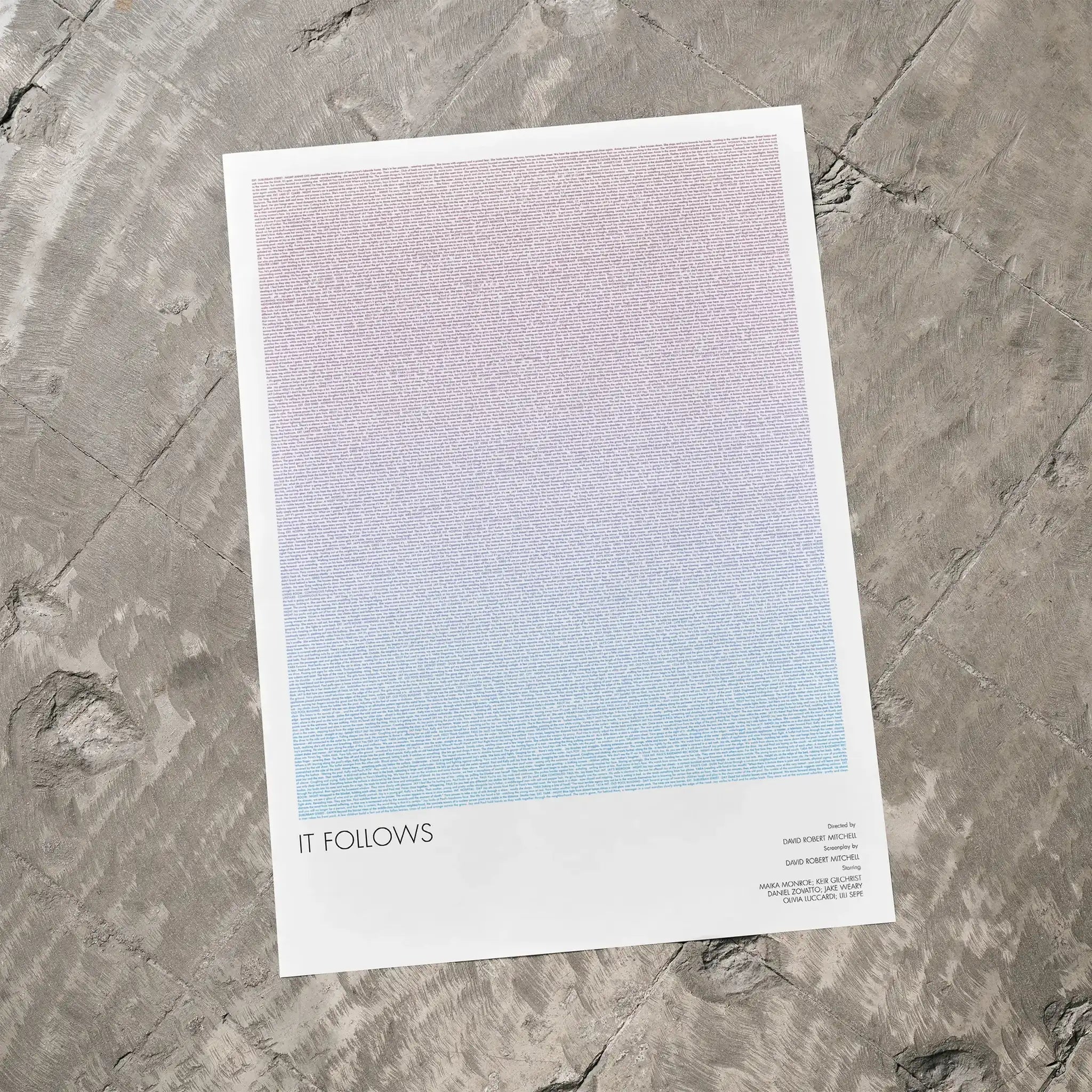 A It Follows movie script poster laid flat on a textured floor surface.
