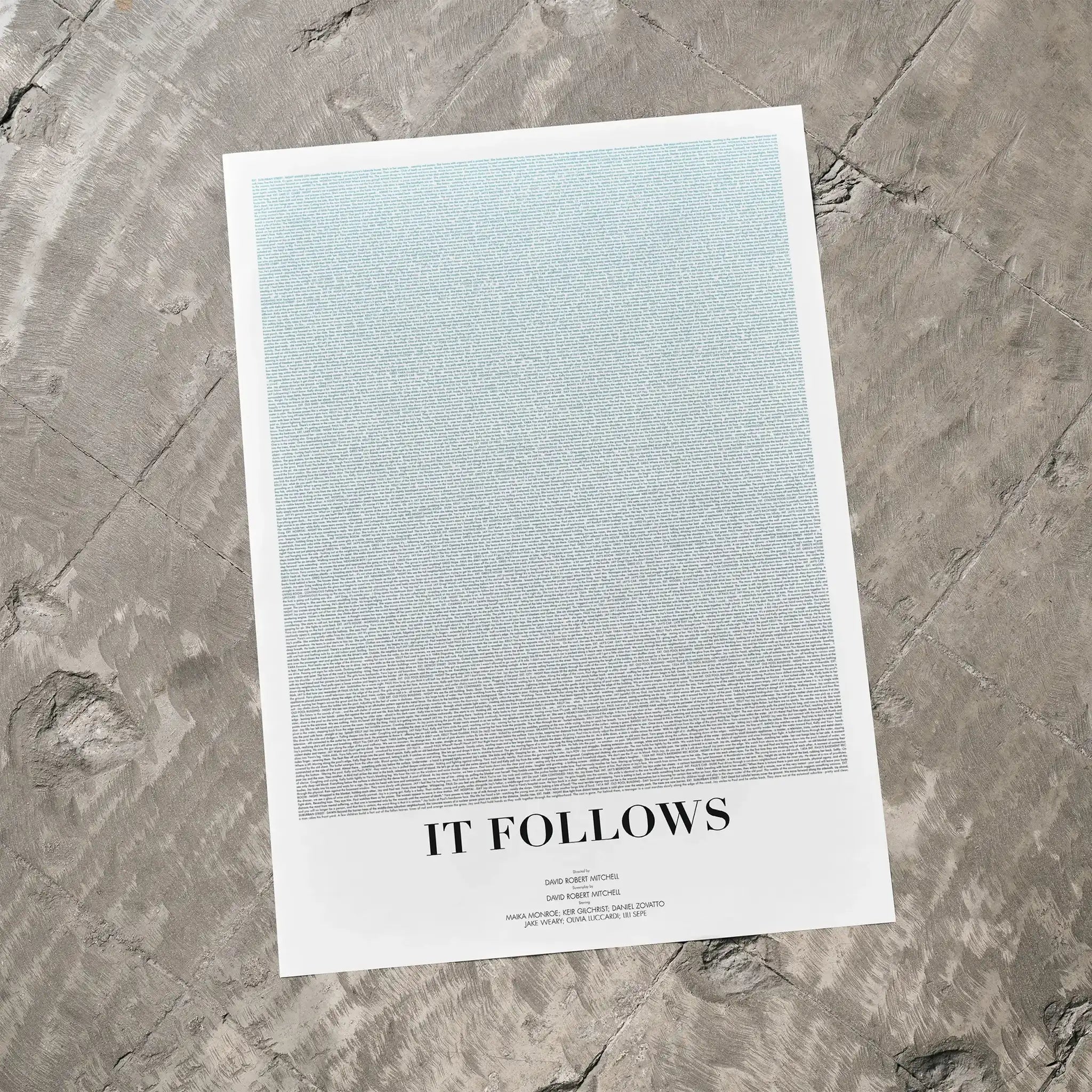 A It Follows movie script poster laid flat on a textured floor surface.
