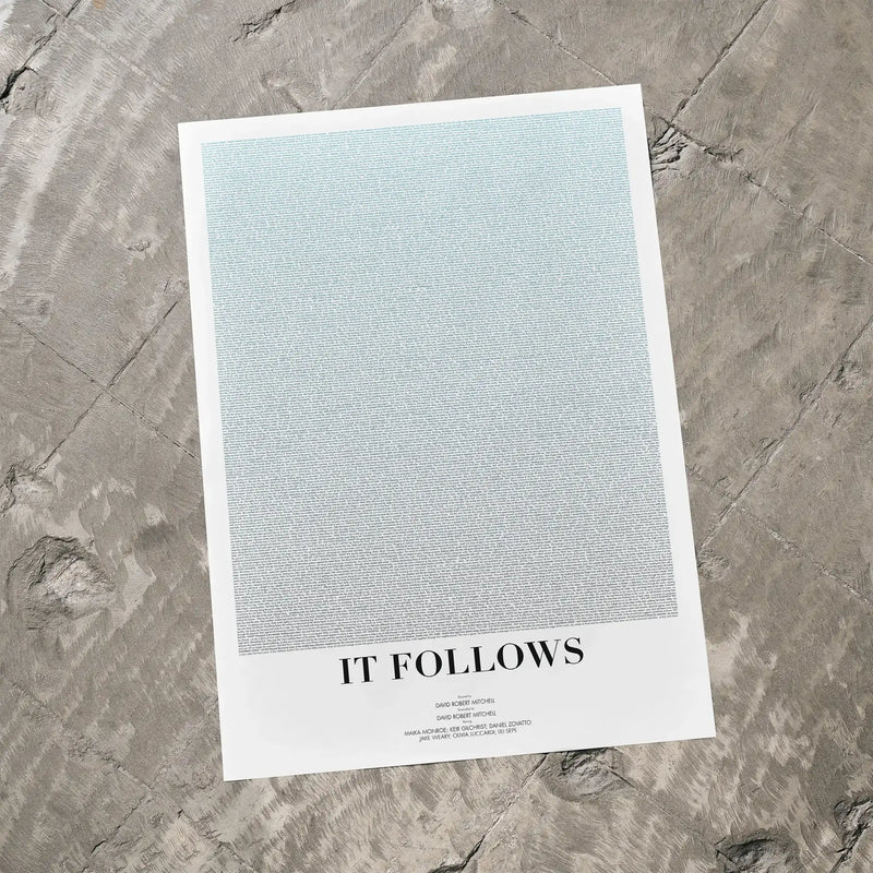 A It Follows movie script poster laid flat on a textured floor surface.