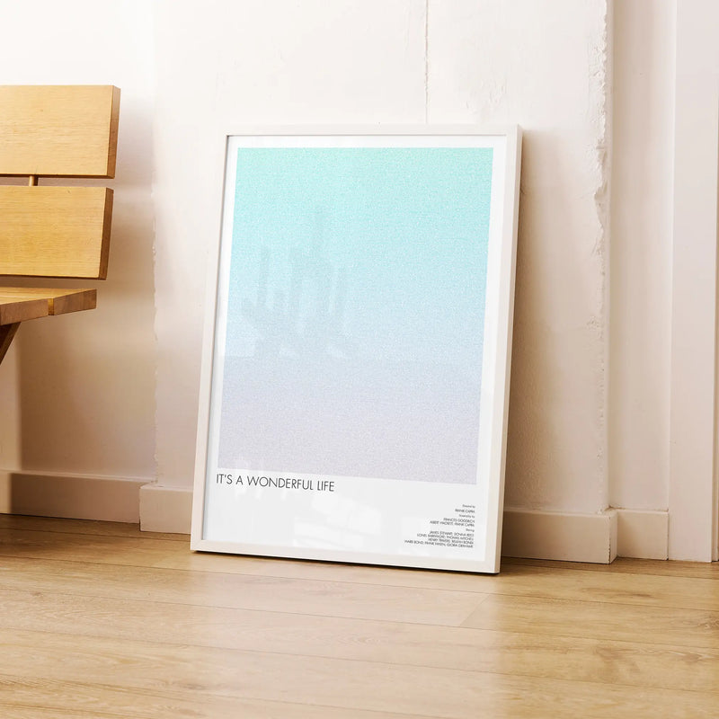 A framed It's a Wonderful Life movie script poster leaning against a wall in a modern interior.