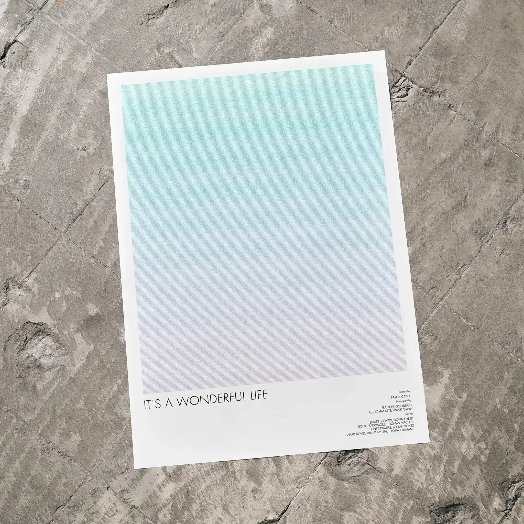 A It's a Wonderful Life movie script poster laid flat on a textured floor surface.