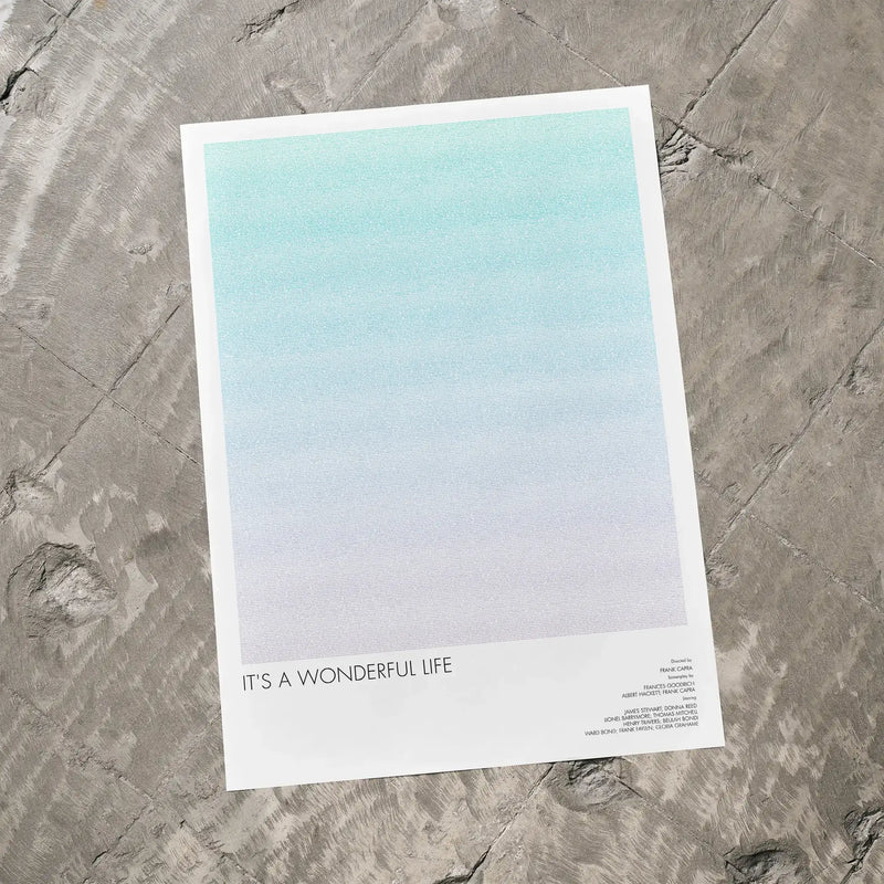 A It's a Wonderful Life movie script poster laid flat on a textured floor surface.