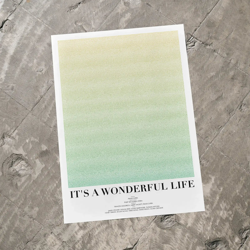A It's a Wonderful Life movie script poster laid flat on a textured floor surface.