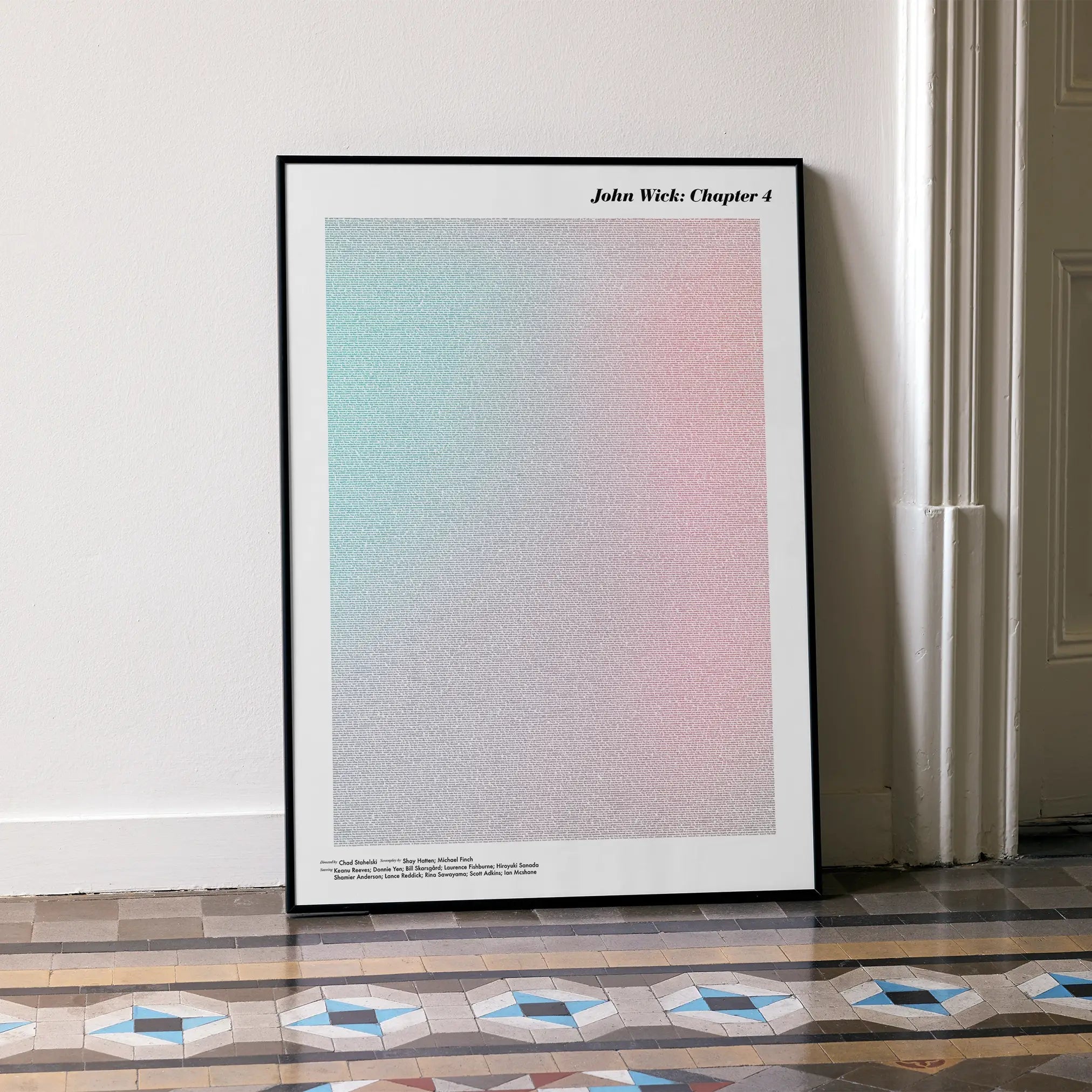 A framed John Wick: Chapter 4 movie script poster leaning against a wall in a minimalist interior.