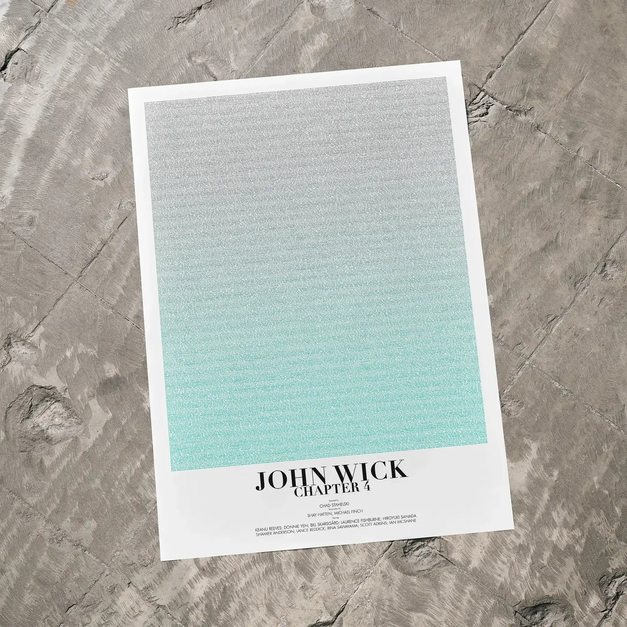 A John Wick: Chapter 4 movie script poster laid flat on a textured floor surface.