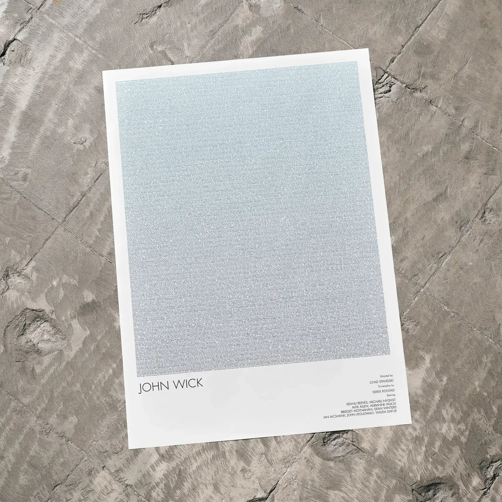 A John Wick movie script poster laid flat on a textured floor surface.