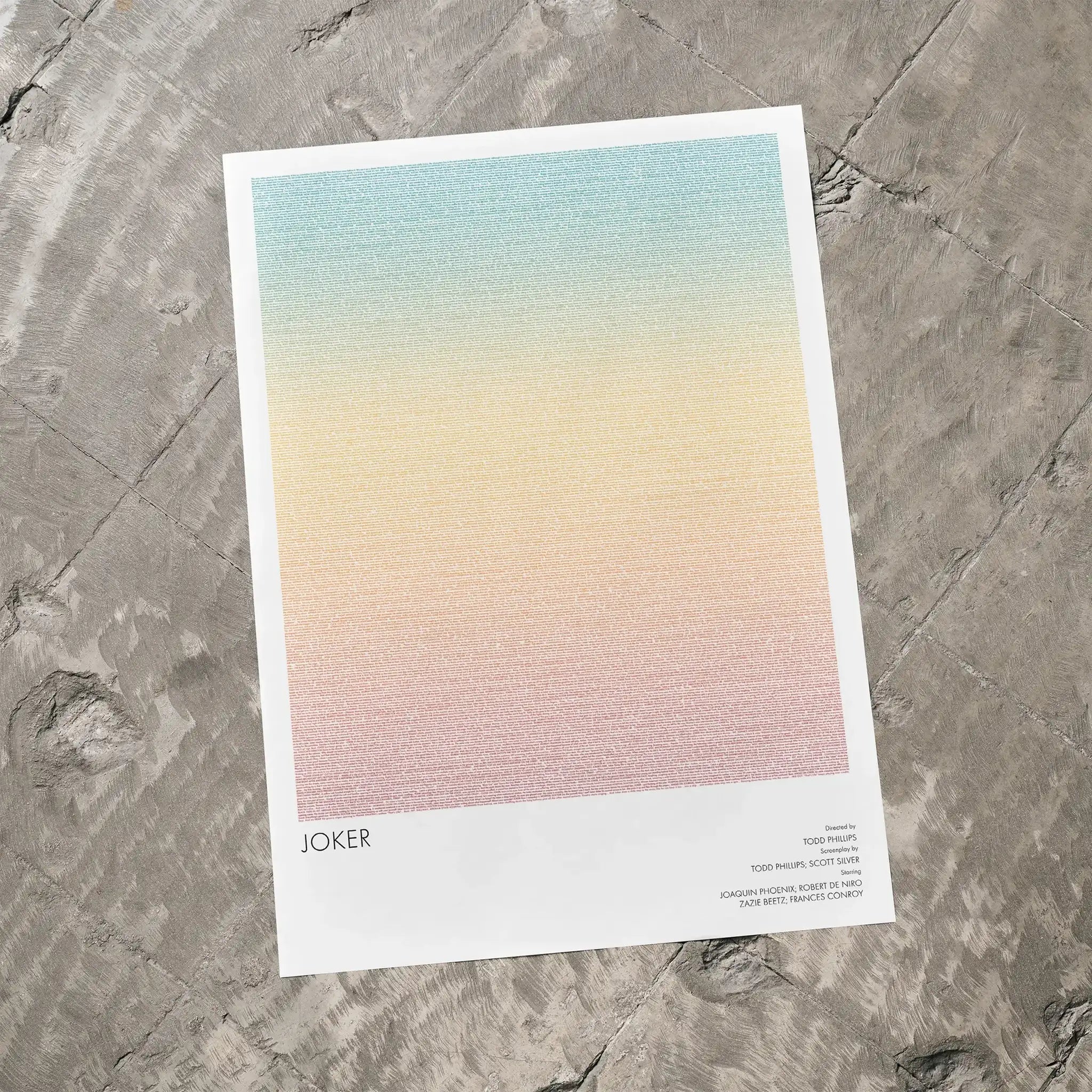 A Joker movie script poster laid flat on a textured floor surface.