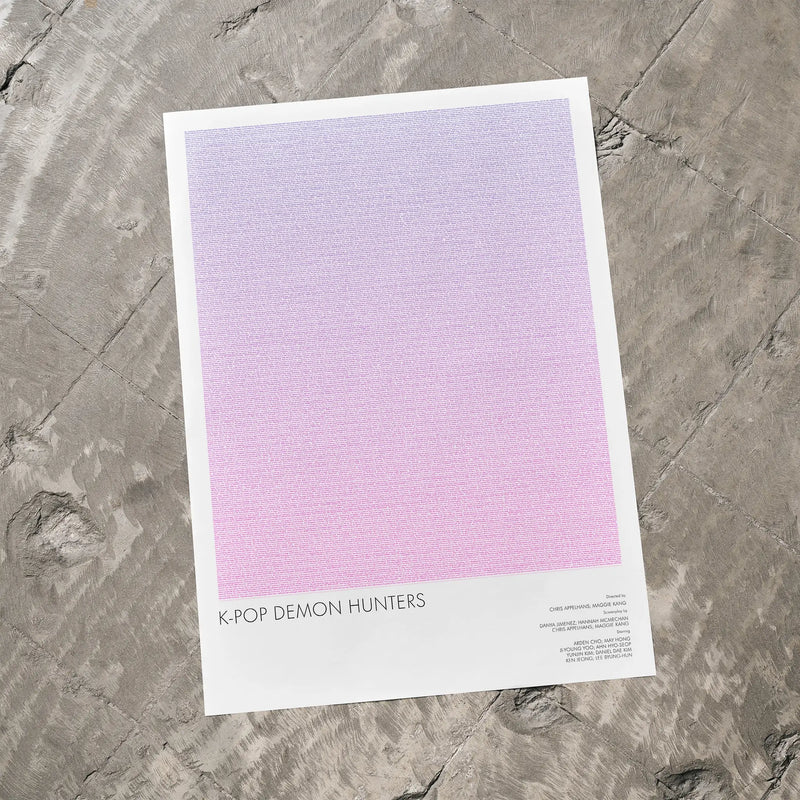 A K-Pop Demon Hunters movie script poster laid flat on a textured floor surface.