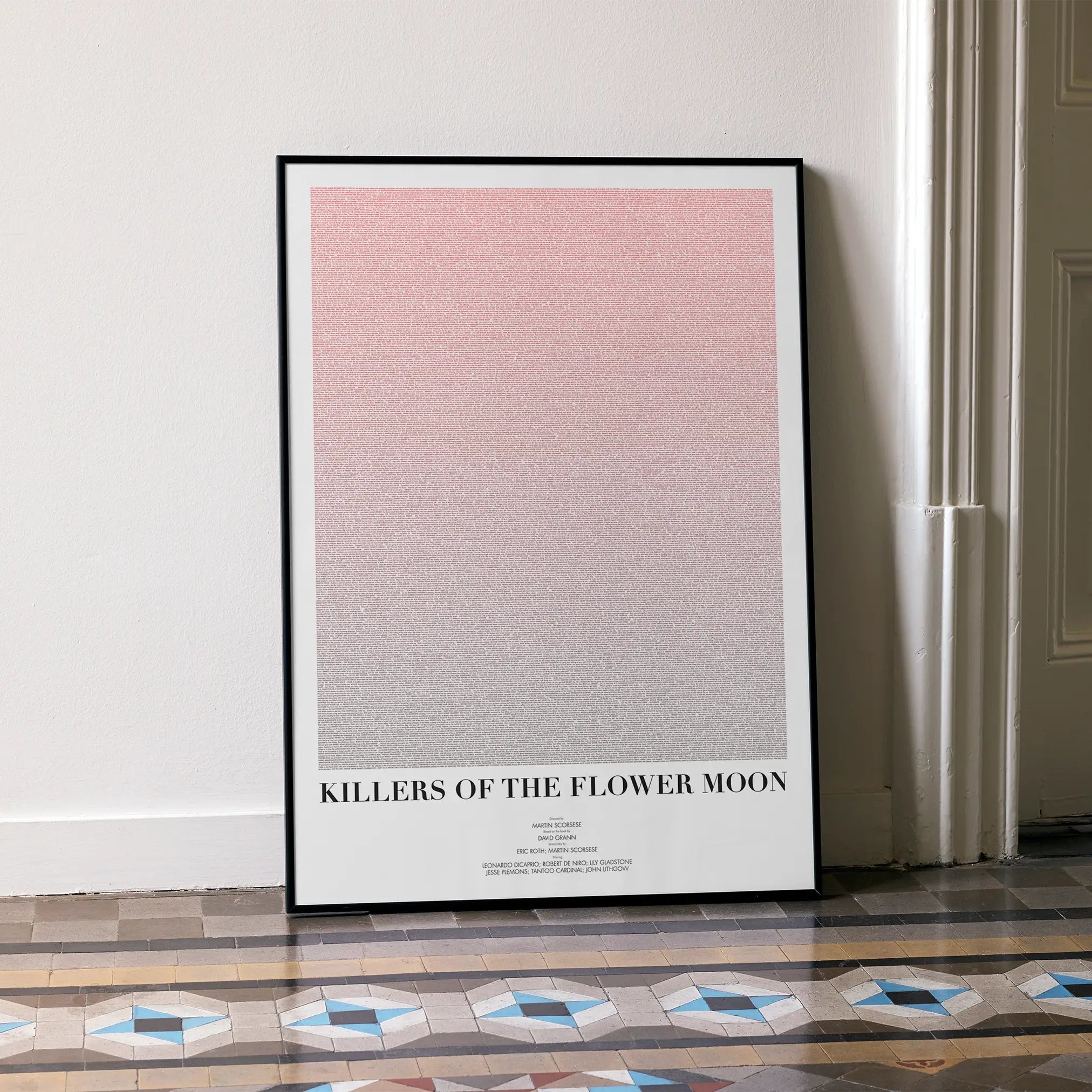 A framed Killers of the Flower Moon movie script poster leaning against a wall in a minimalist interior.