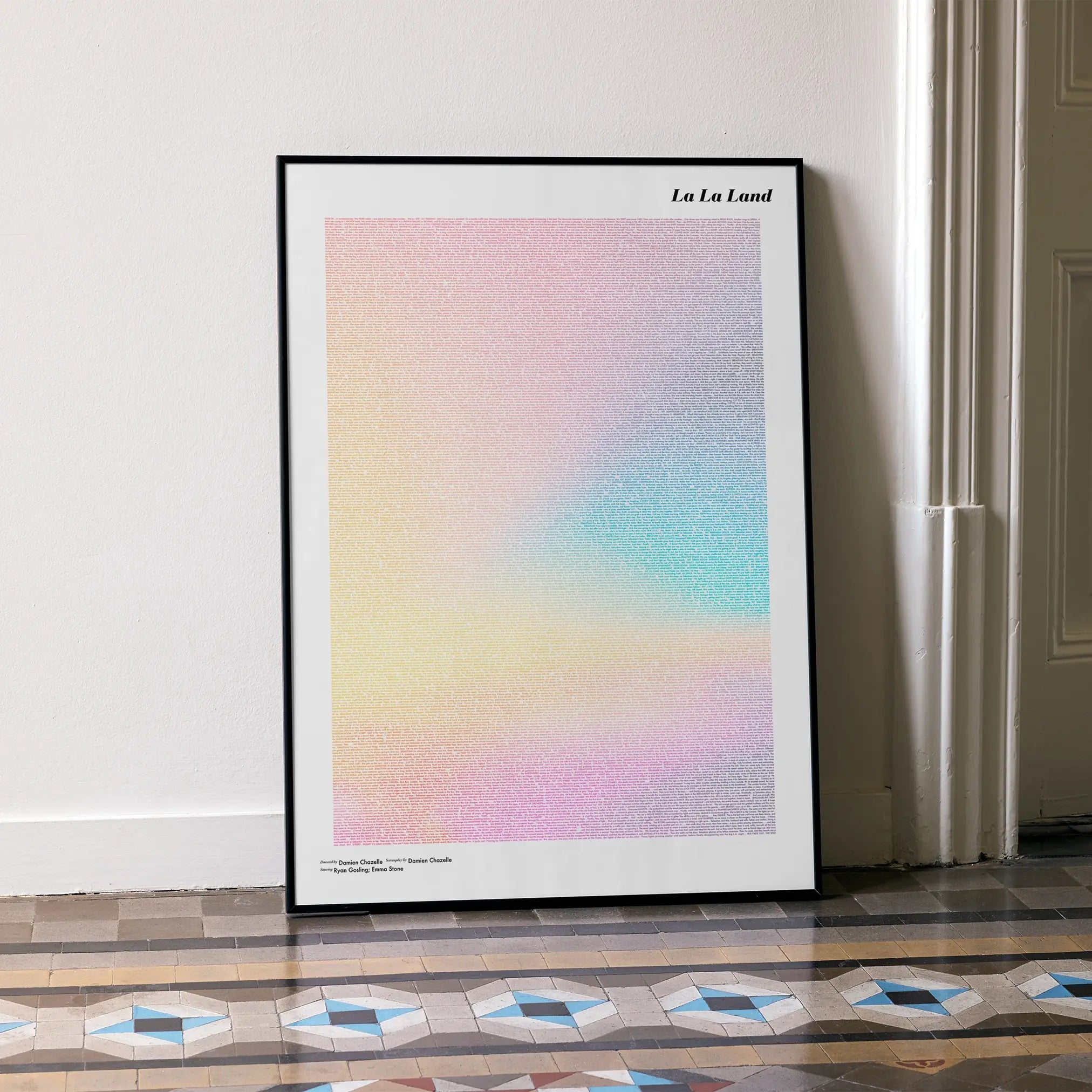 A framed La La Land movie script poster leaning against a wall in a minimalist interior.