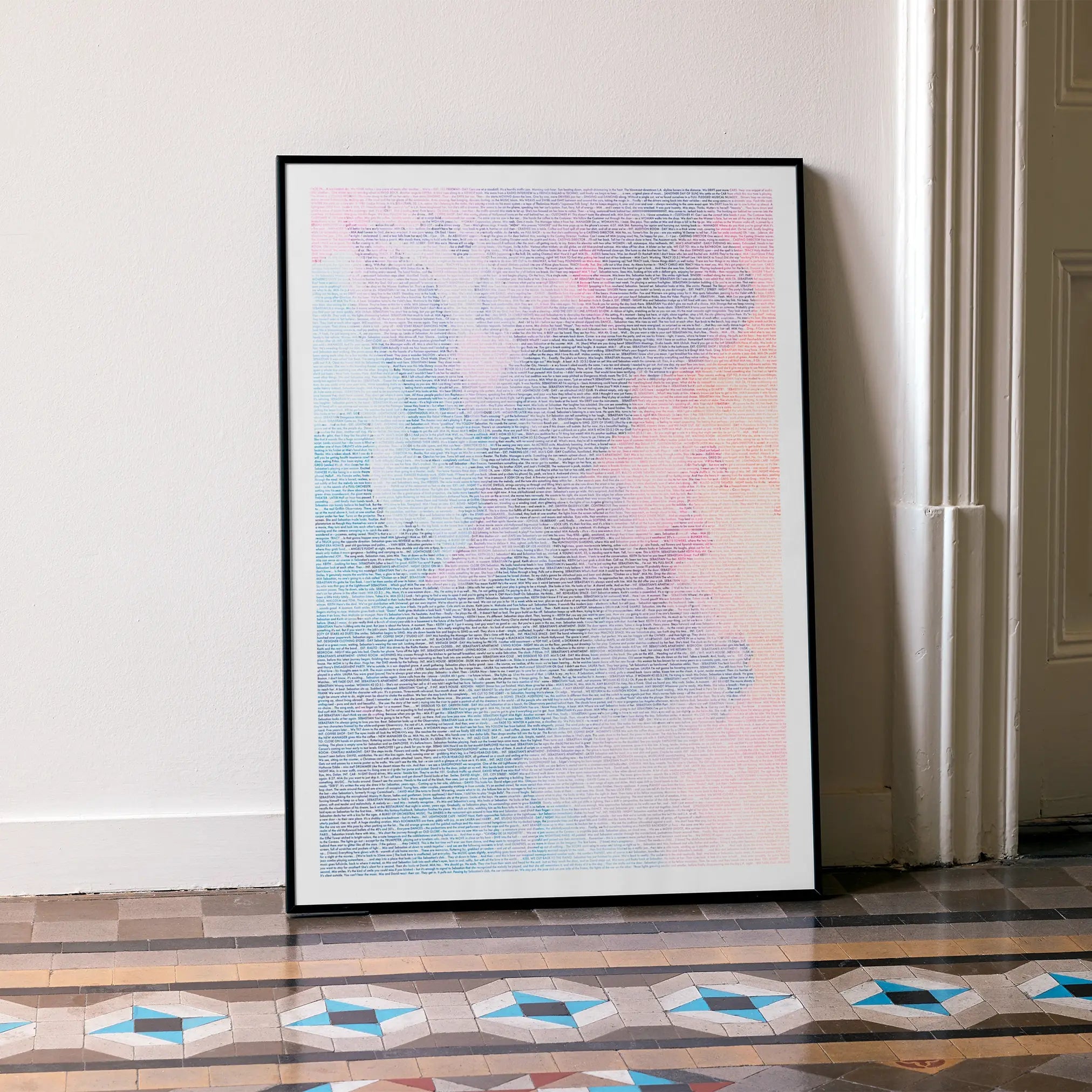 A framed La La Land movie script poster leaning against a wall in a minimalist interior.