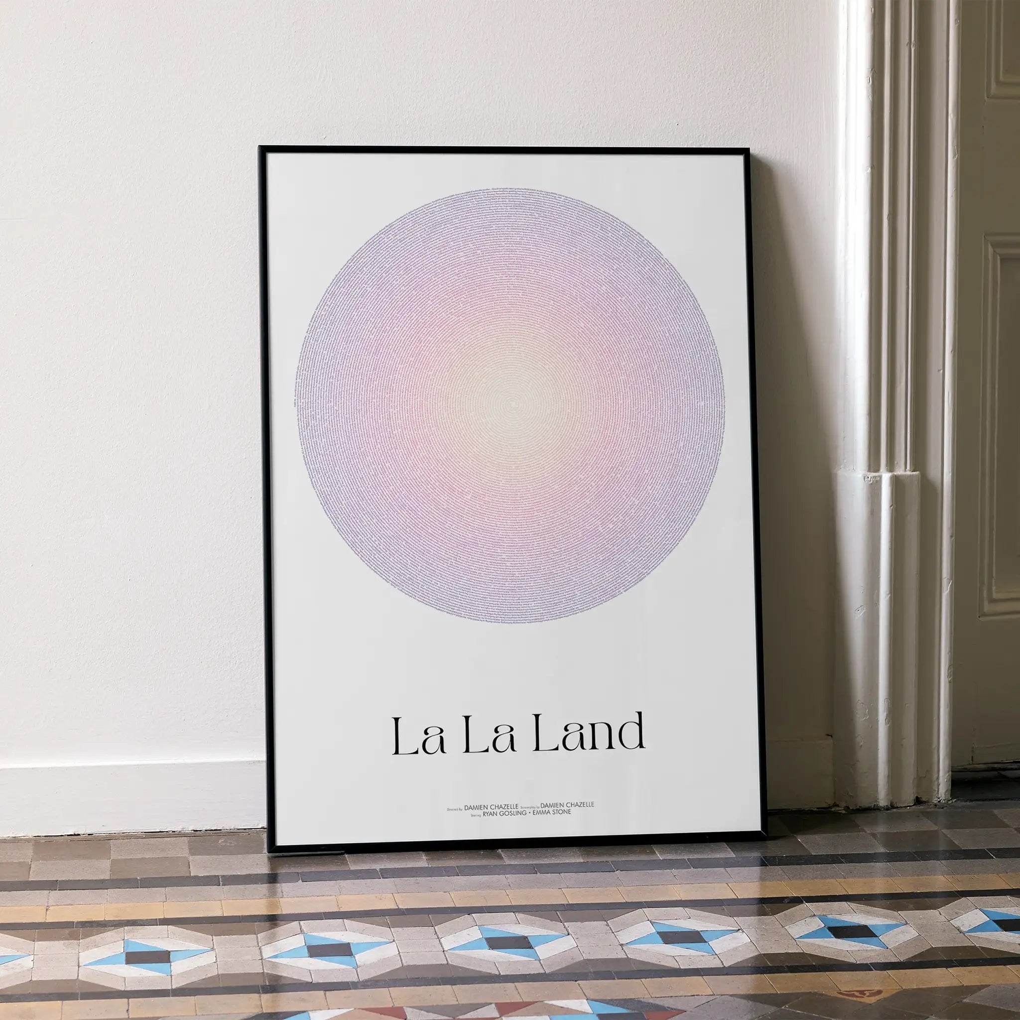 A framed La La Land movie script poster leaning against a wall in a minimalist interior.