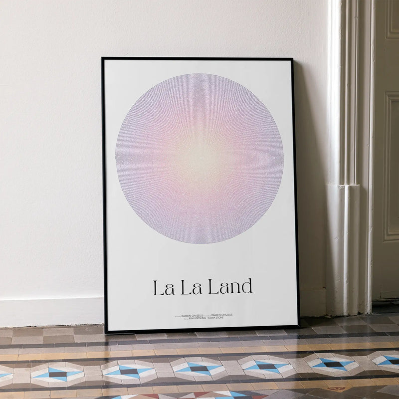 A framed La La Land movie script poster leaning against a wall in a minimalist interior.