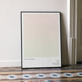 A framed Little Women movie script poster leaning against a wall in a minimalist interior.