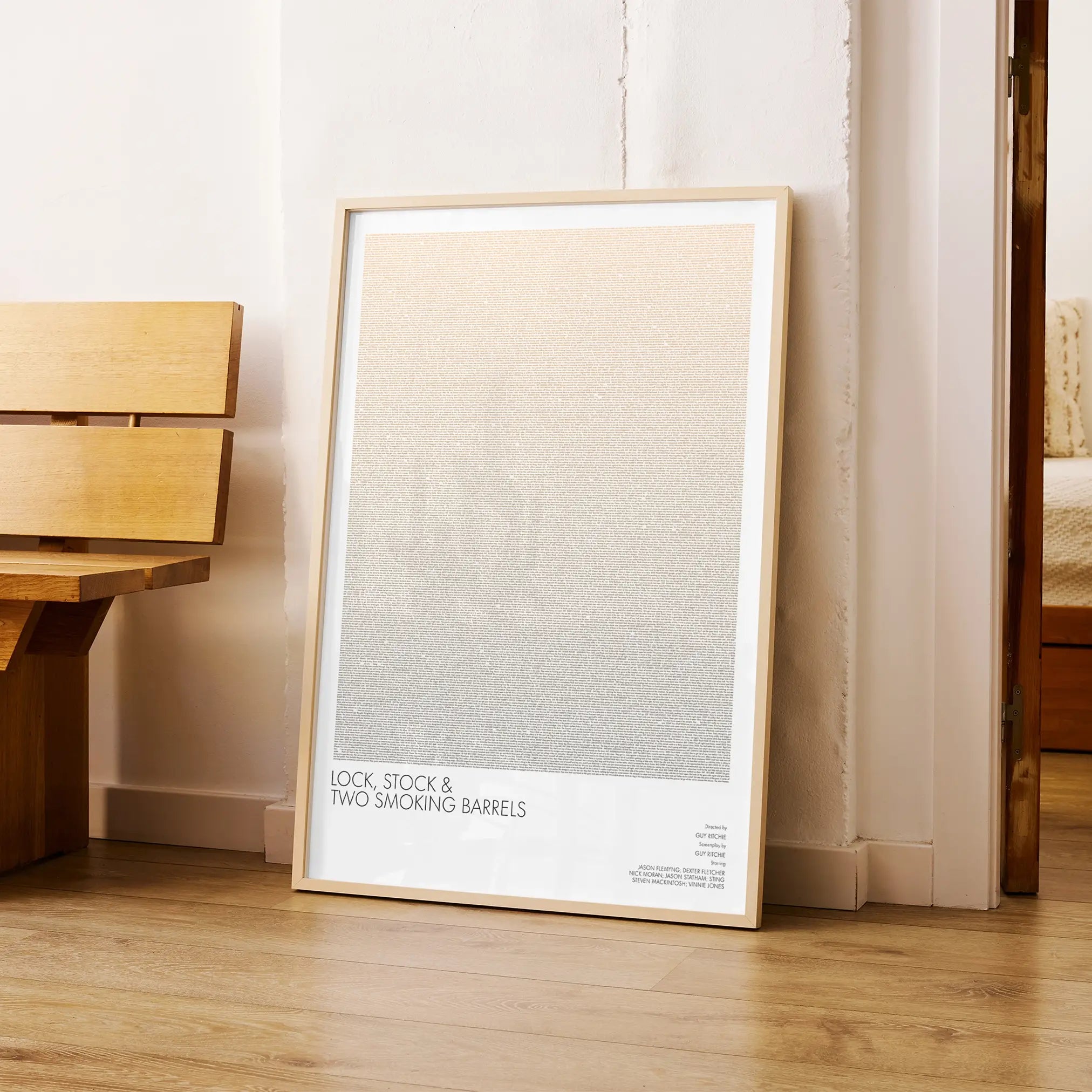 A framed Lock, Stock and Two Smoking Barrels movie script poster arranged in a minimalist interior setting.