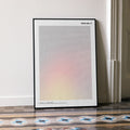 A framed Malcolm X movie script poster leaning against a wall in a minimalist interior.
