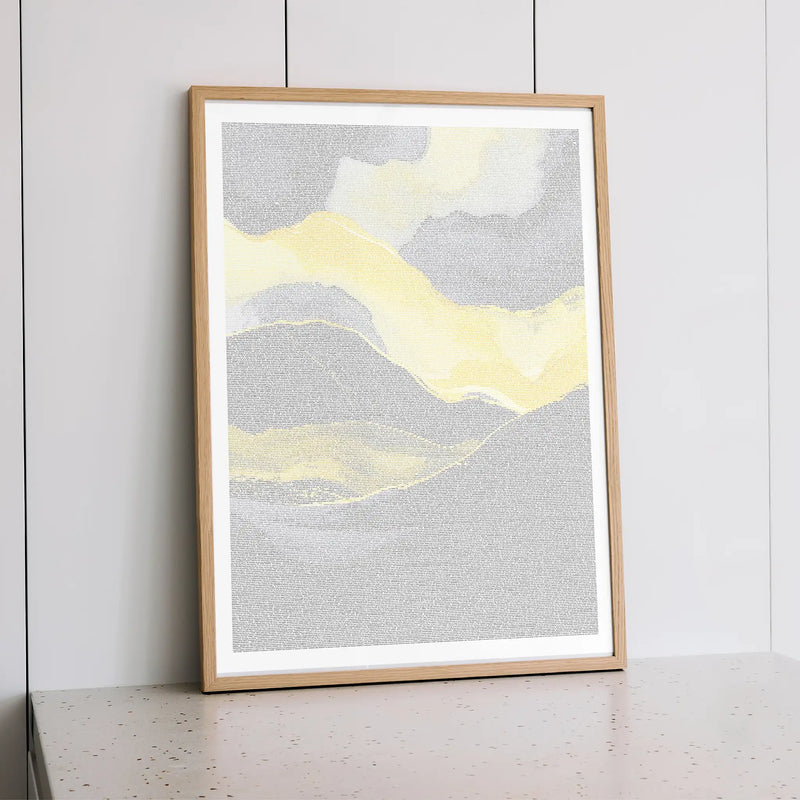 Framed Malcolm X abstract art print with yellow and gray colors on a white wall.