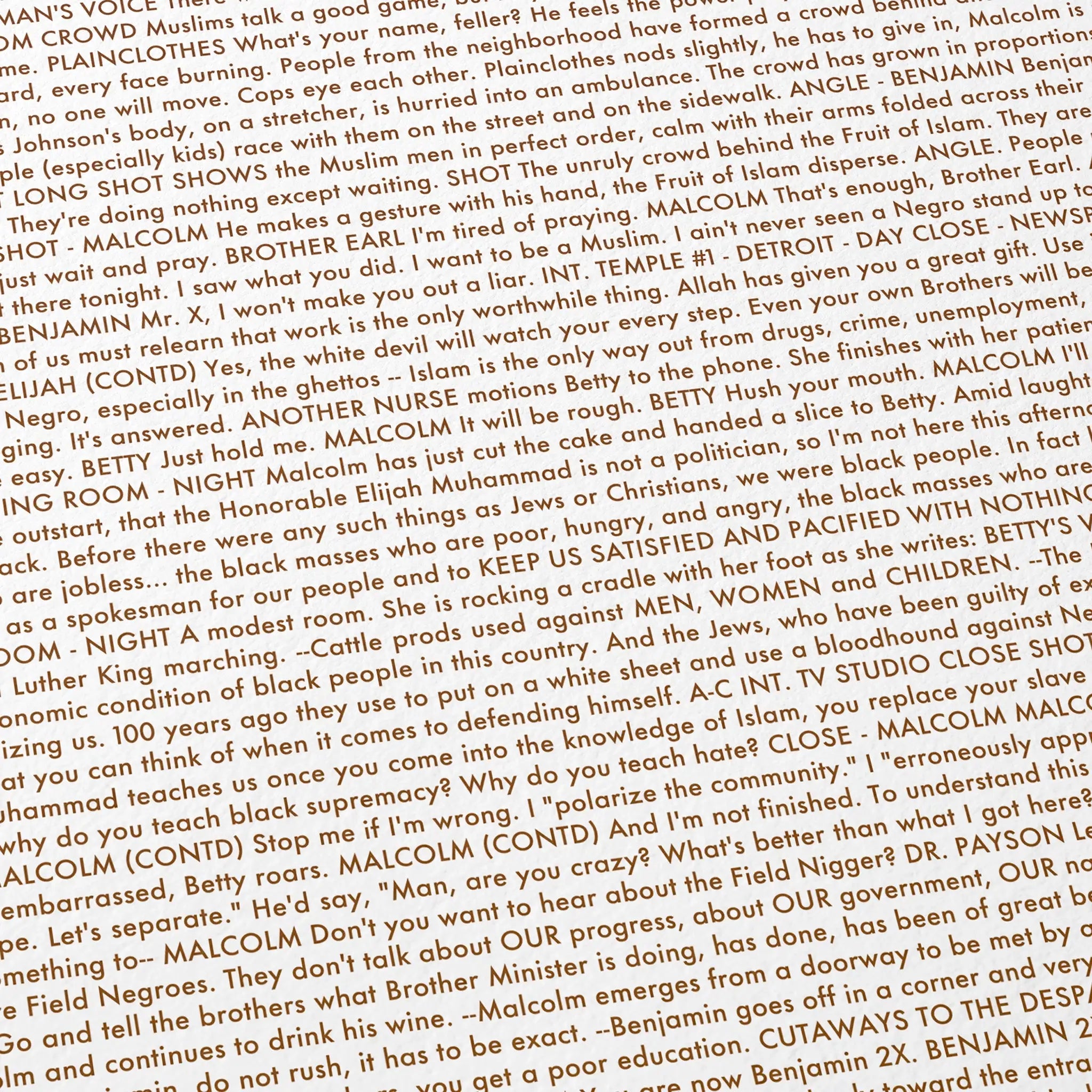Close-up detail of the Malcolm X movie script poster showing dense typographic text.