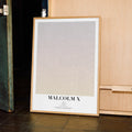 A framed Malcolm X movie script poster displayed in a contemporary interior setting.