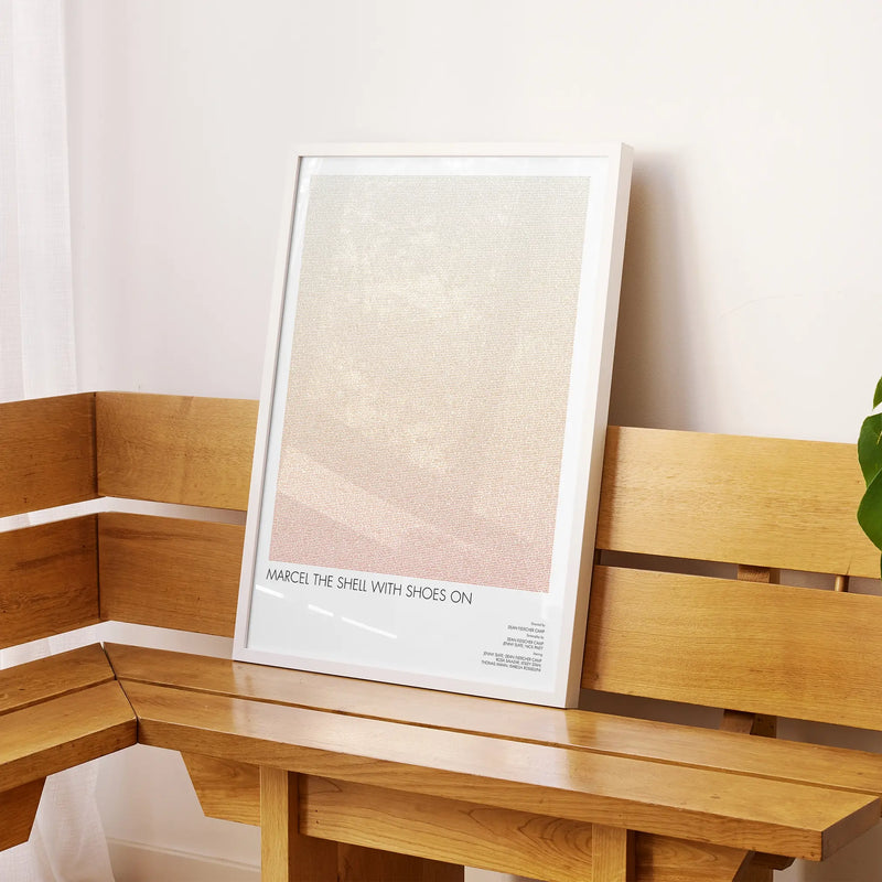 A framed Marcel the Shell with Shoes On movie script poster displayed on a sideboard in a contemporary space.