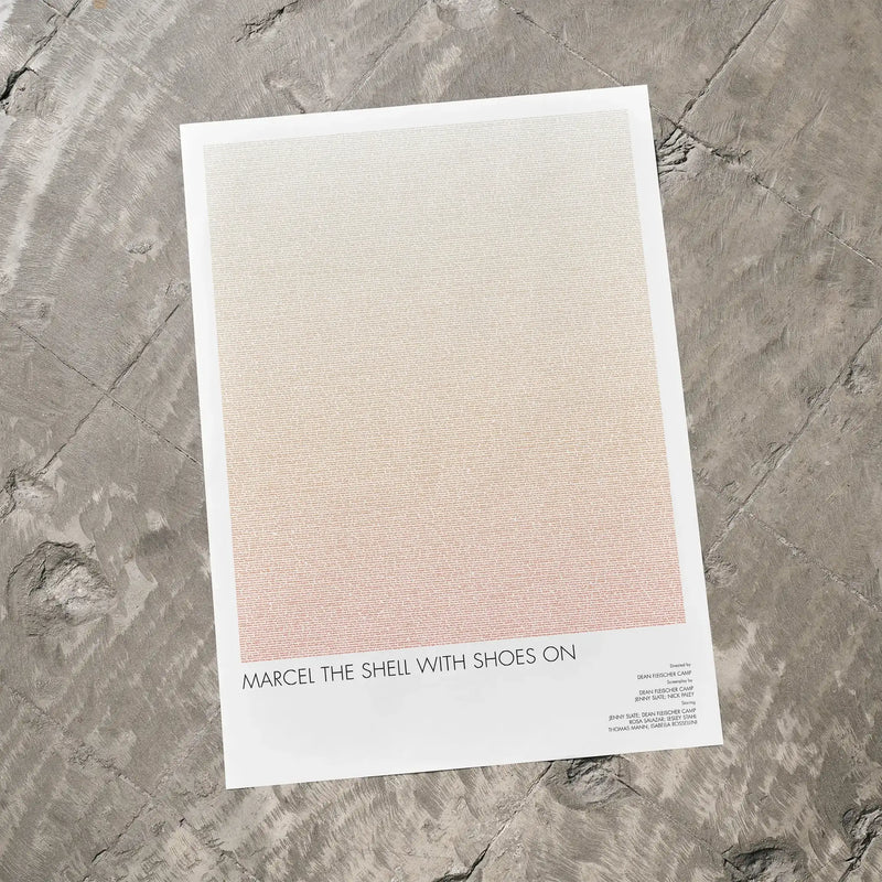 A Marcel the Shell with Shoes On movie script poster laid flat on a textured floor surface.