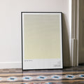 A framed M*A*S*H movie script poster leaning against a wall in a minimalist interior.