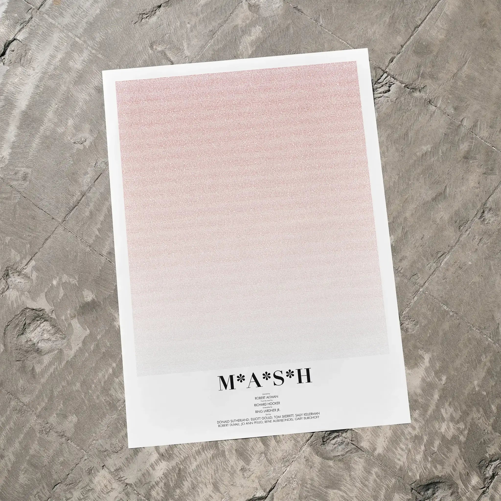 A M*A*S*H movie script poster laid flat on a textured floor surface.