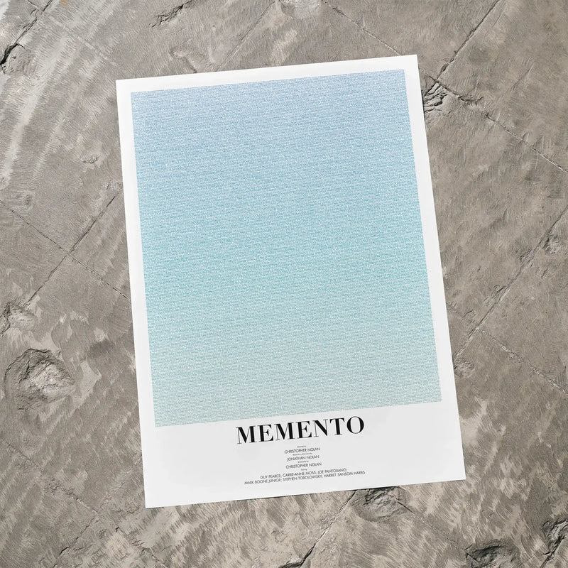 A Memento movie script poster laid flat on a textured floor surface.