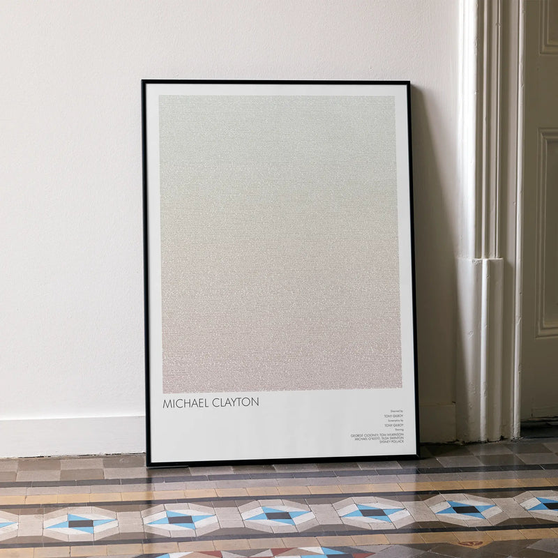 A framed Michael Clayton movie script poster leaning against a wall in a minimalist interior.