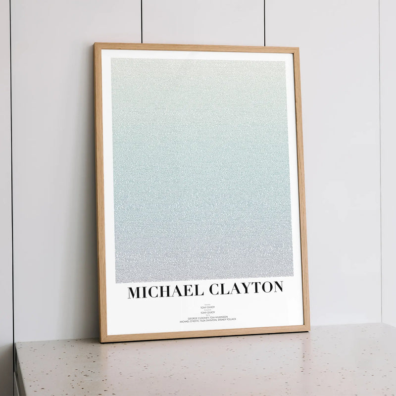 A framed Michael Clayton movie script poster styled within a calm interior space.