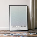 A framed Michael Clayton movie script poster leaning against a wall in a minimalist interior.