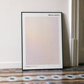 A framed Mistress America movie script poster leaning against a wall in a minimalist interior.