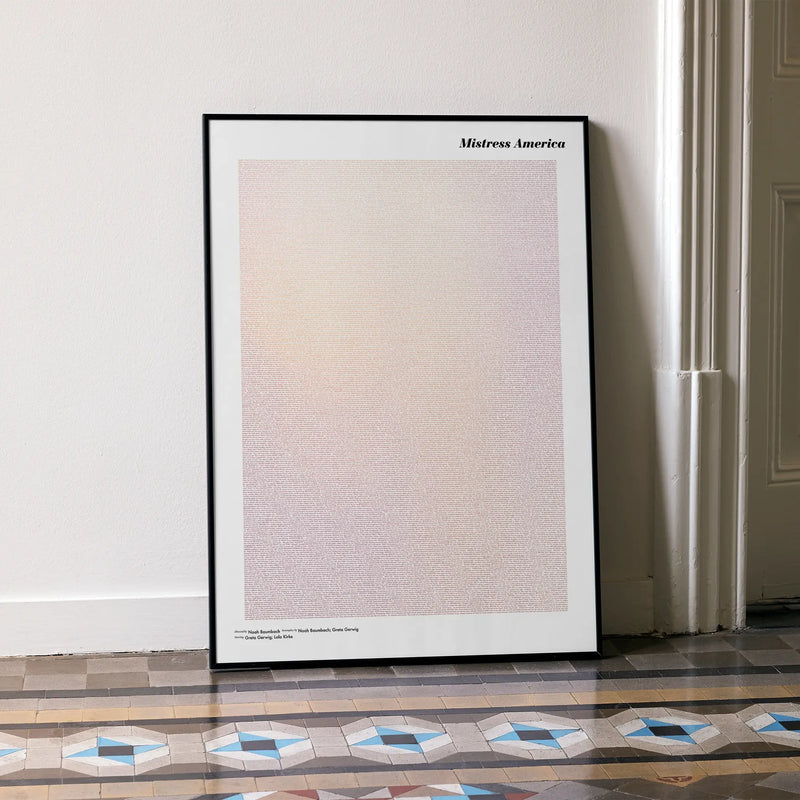 A framed Mistress America movie script poster leaning against a wall in a minimalist interior.