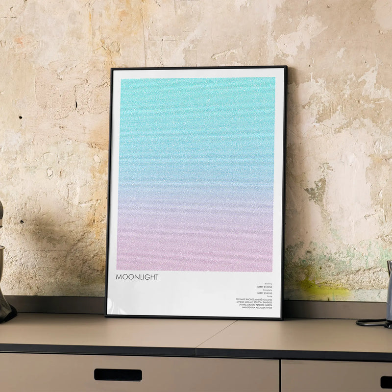 A framed Moonlight movie script poster displayed on a cabinet in a minimalist interior.