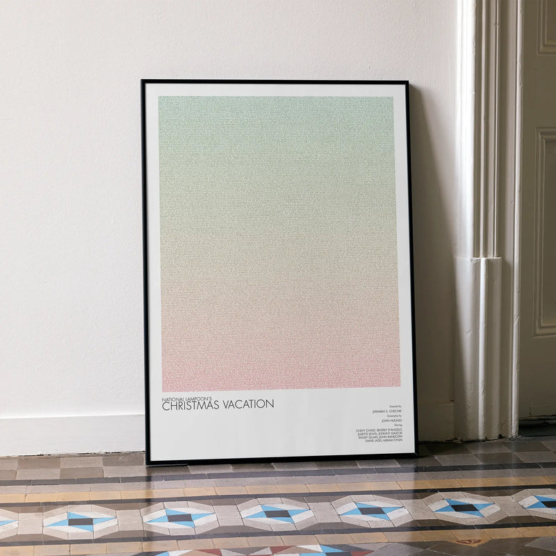 A framed National Lampoon's Christmas Vacation movie script poster leaning against a wall in a minimalist interior.