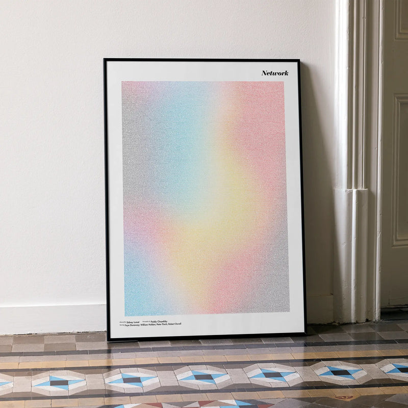 A framed Network movie script poster leaning against a wall in a minimalist interior.