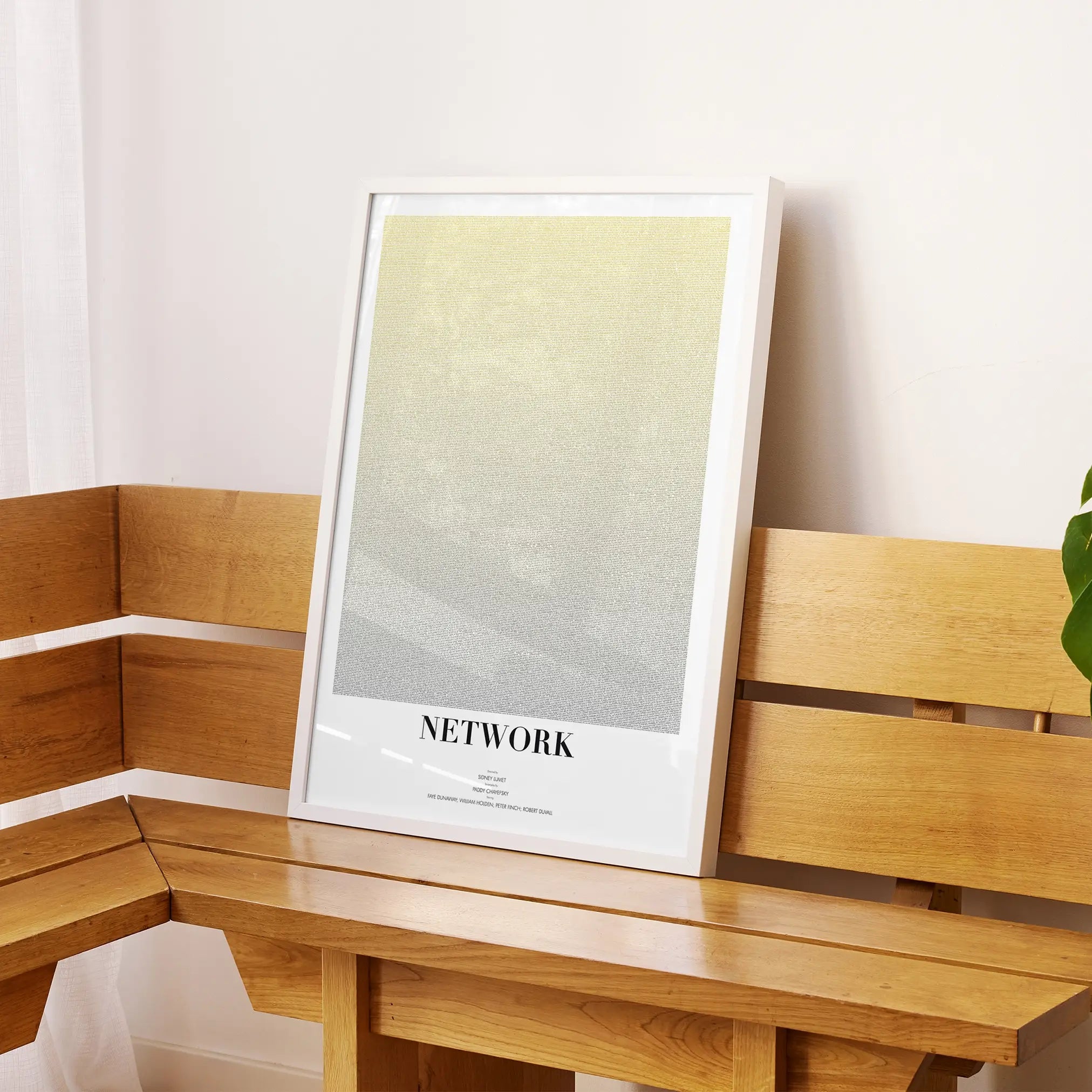 A framed Network movie script poster displayed on a sideboard in a contemporary space.