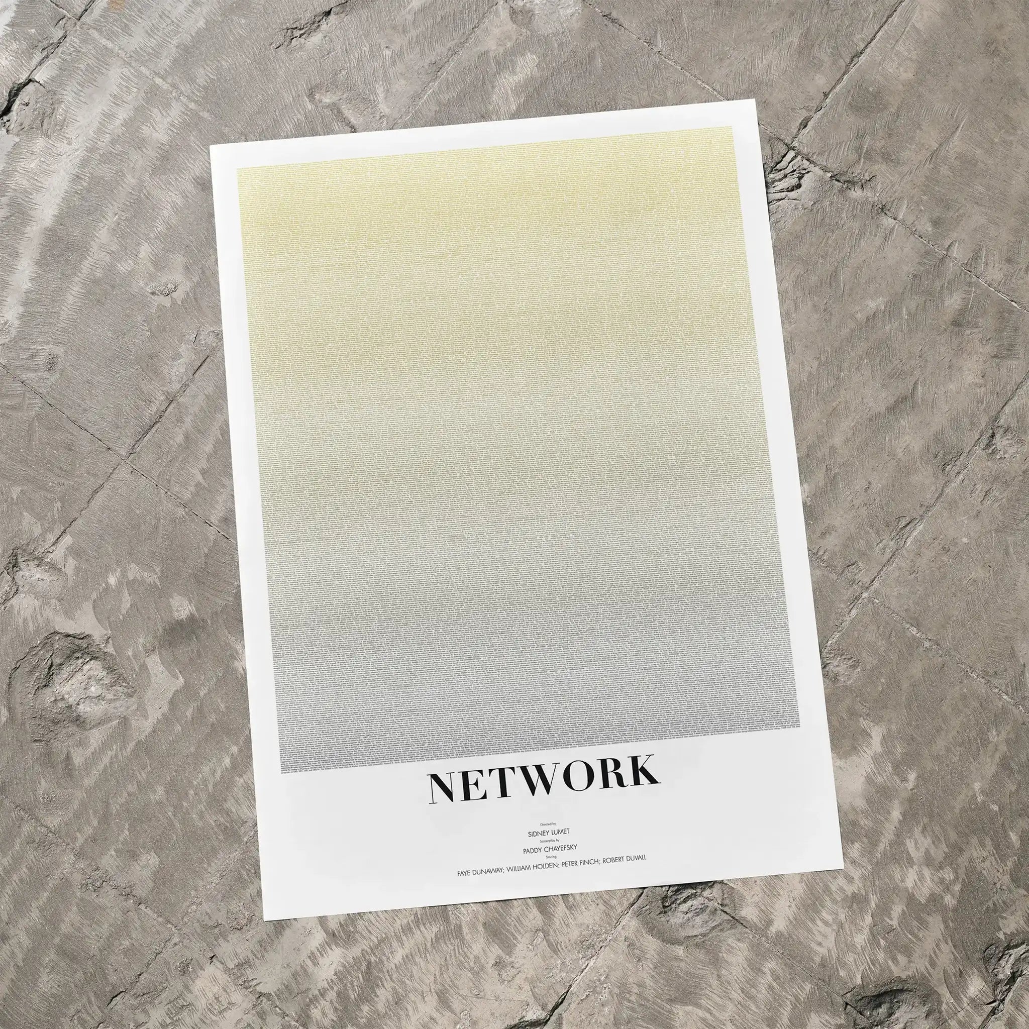 A Network movie script poster laid flat on a textured floor surface.
